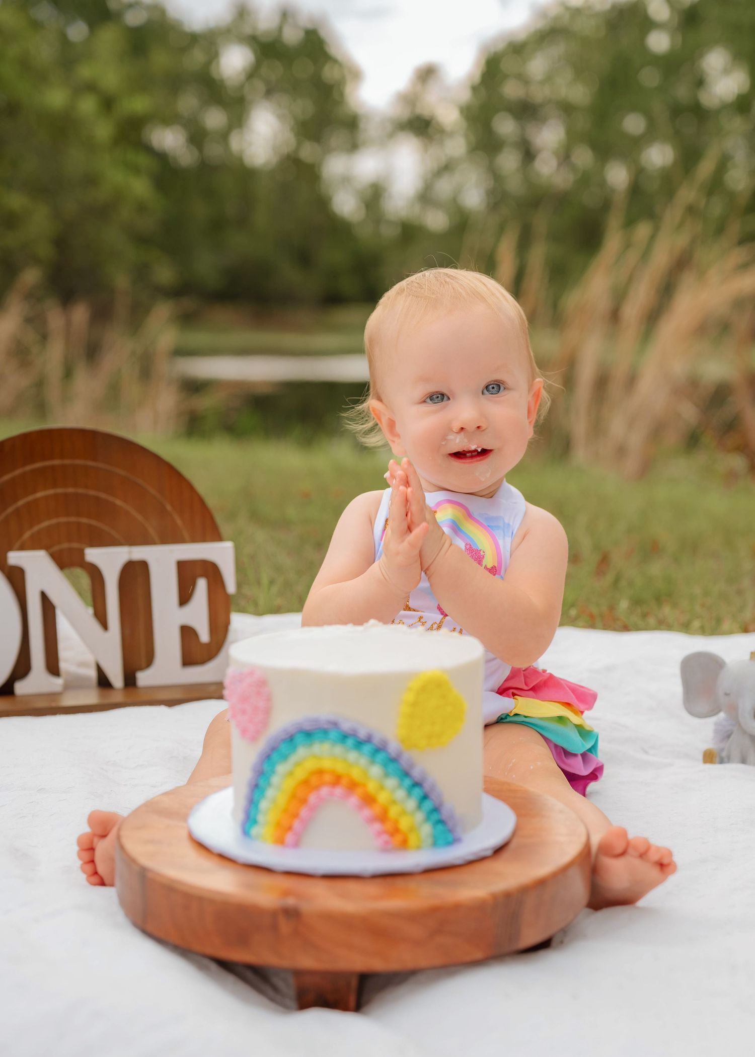 Outdoor cake smash photography documenting the fun and excitement of a first birthday celebration by Orlando family photographer