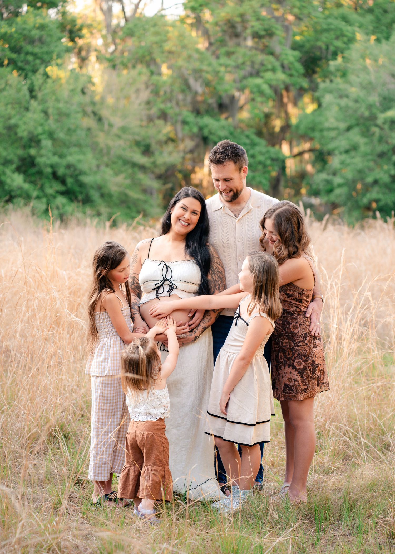 Outdoor family maternity portraits captured among the tall grass at Lake Runnymede Conservation Area in St. Cloud, Florida.