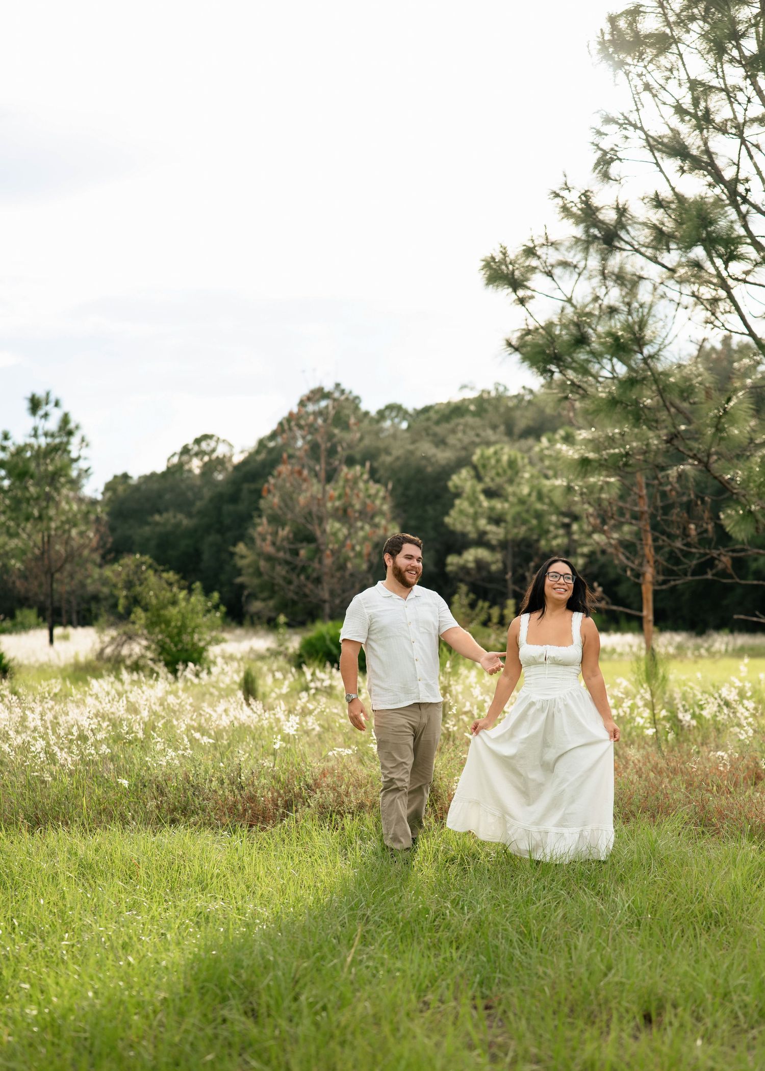 Engaged couple walking through Lake Louisa State Park during sunset during photography session