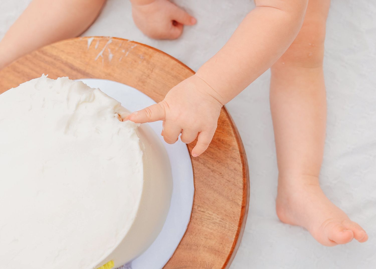 Outdoor cake smash photography documenting the fun and excitement of a first birthday celebration by Orlando family photographer