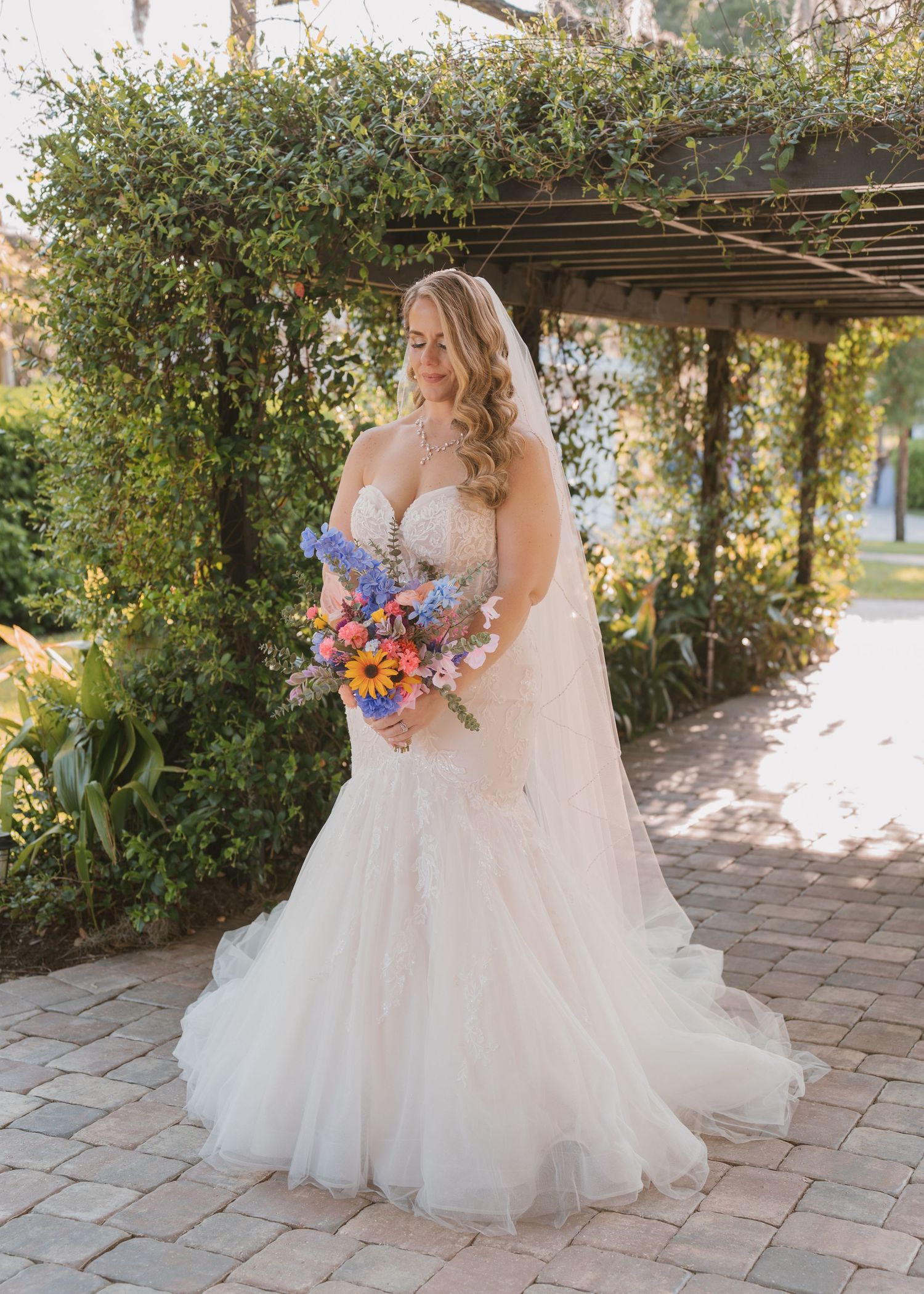 Romantic golden hour bridal portrait featuring the bride's wedding dress and bouquet outdoors at Moss Estates wedding venue in Eustis, Flori