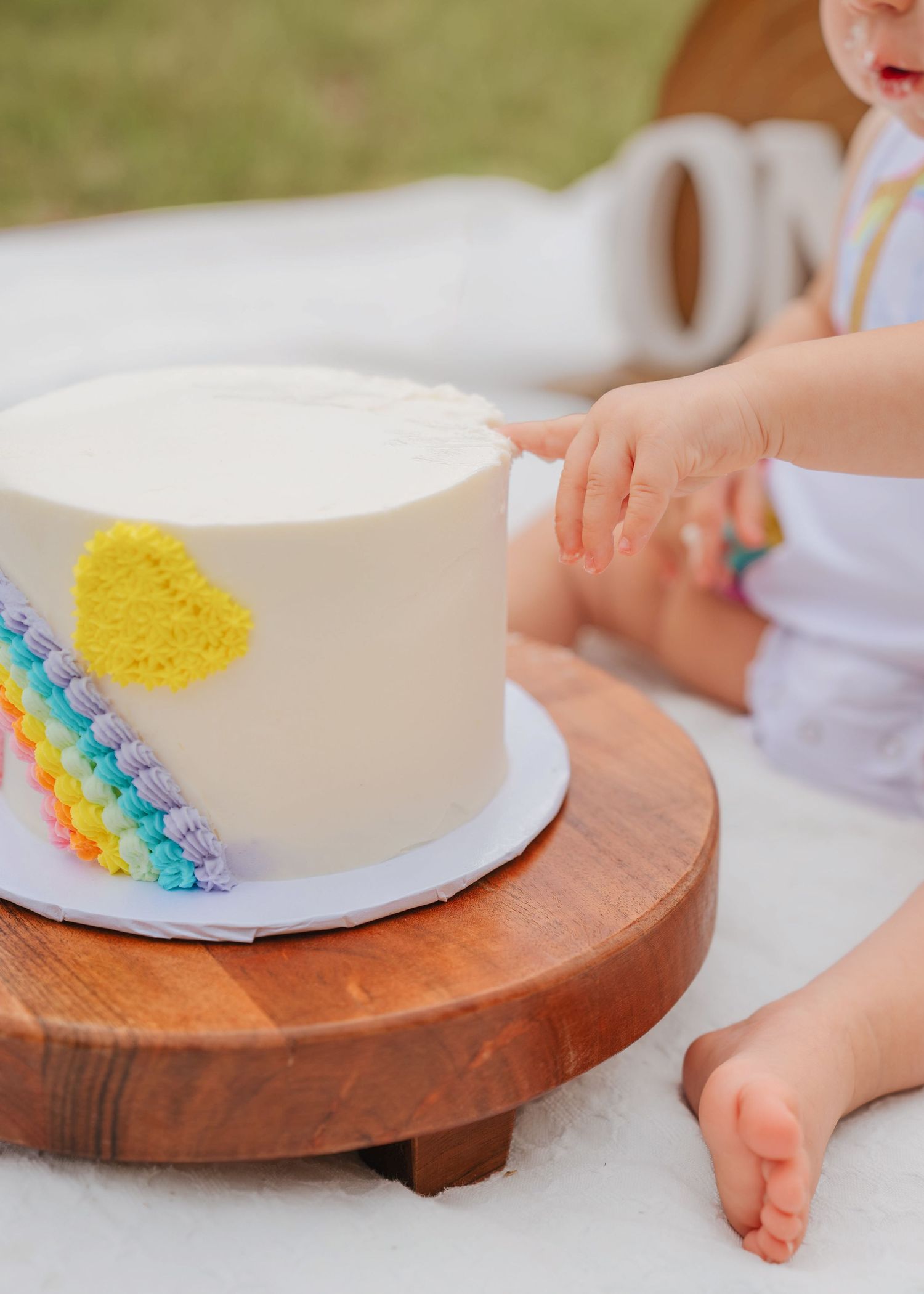 Outdoor cake smash photography documenting the fun and excitement of a first birthday celebration by Orlando family photographer
