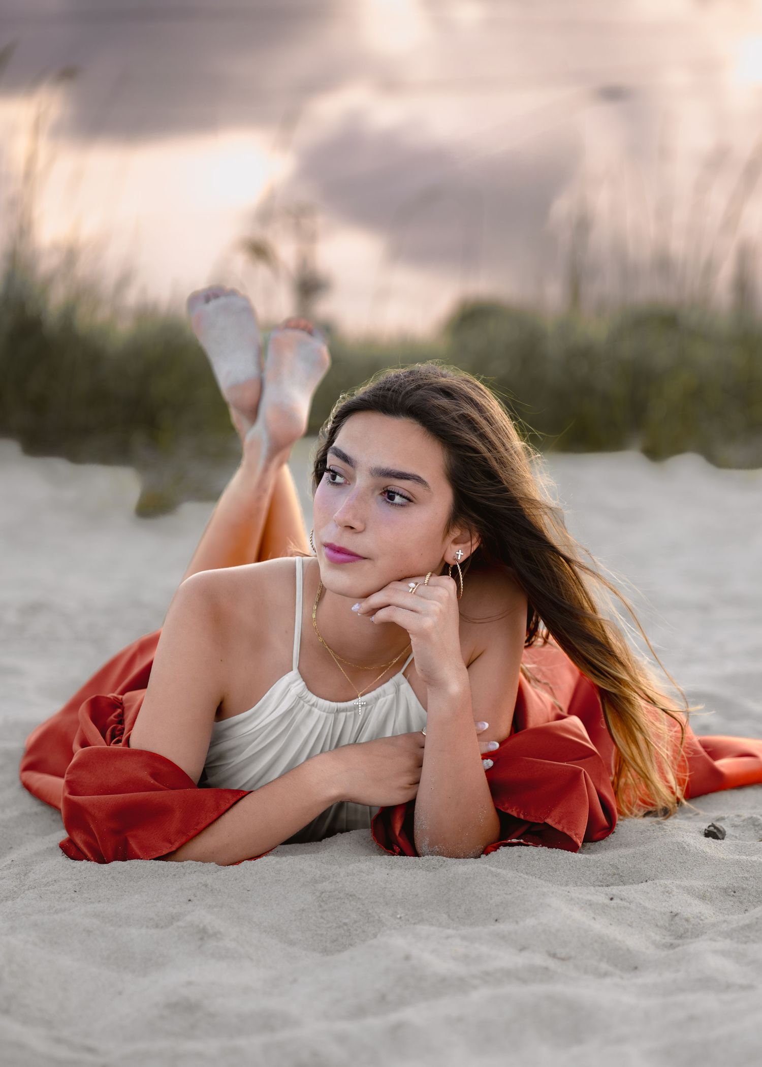 Stunning graduation portrait photography featuring the sandy shoreline and golden sunset at Melbourne Beach with gown.