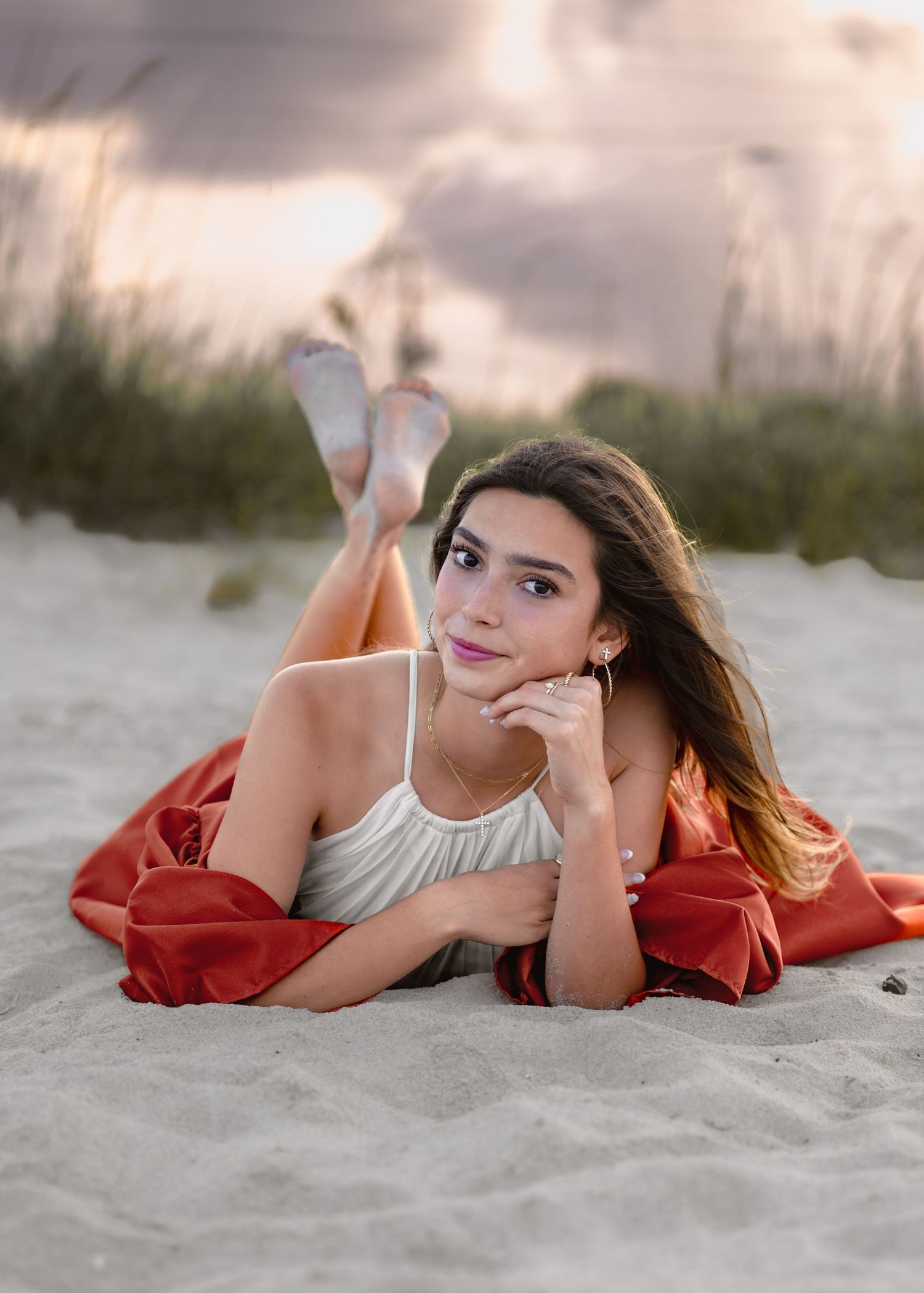 Stunning graduation portrait photography featuring the sandy shoreline and golden sunset at Melbourne Beach with gown.
