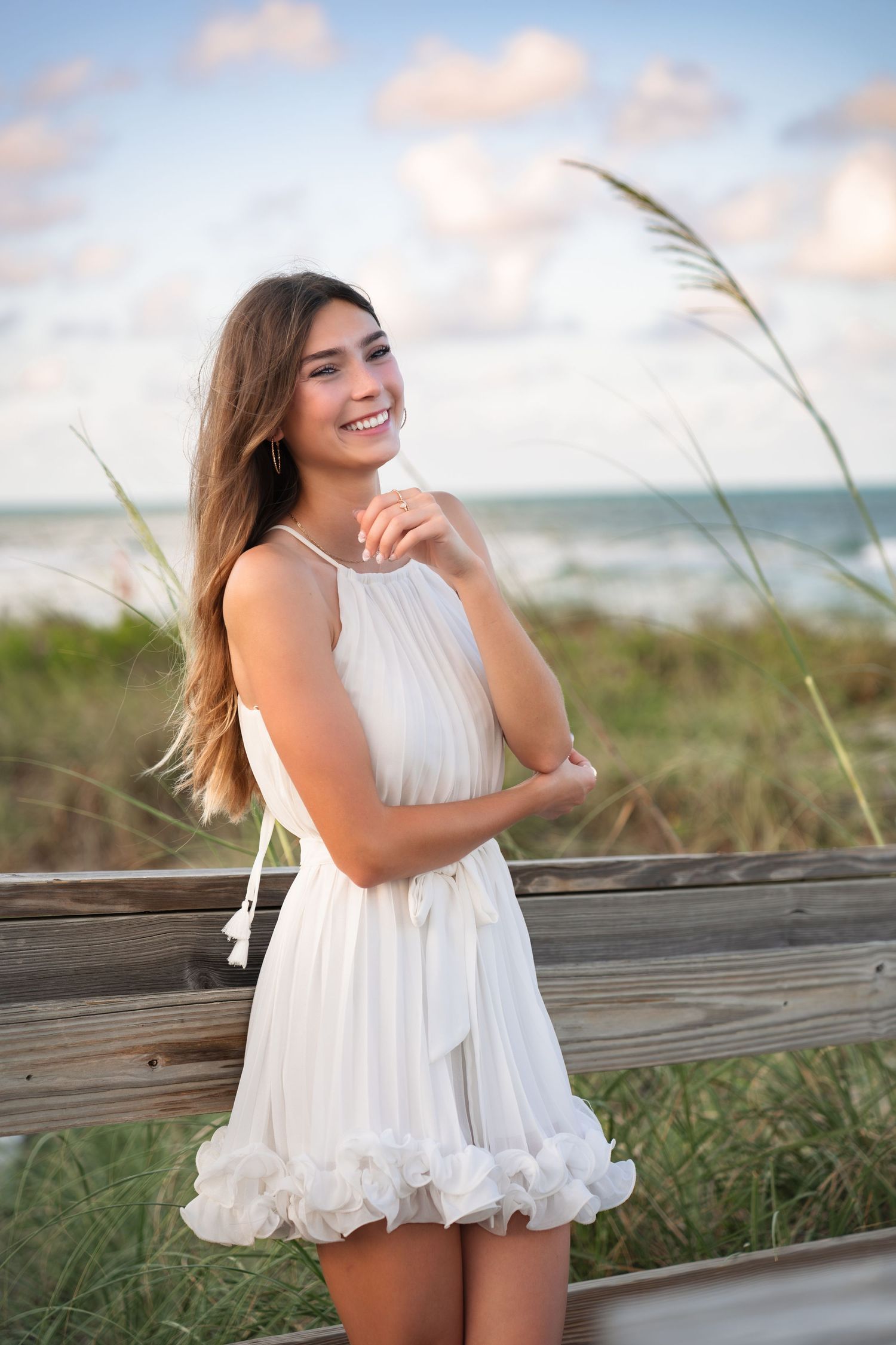 Graduate smiling during a sunset senior session at Melbourne Beach.