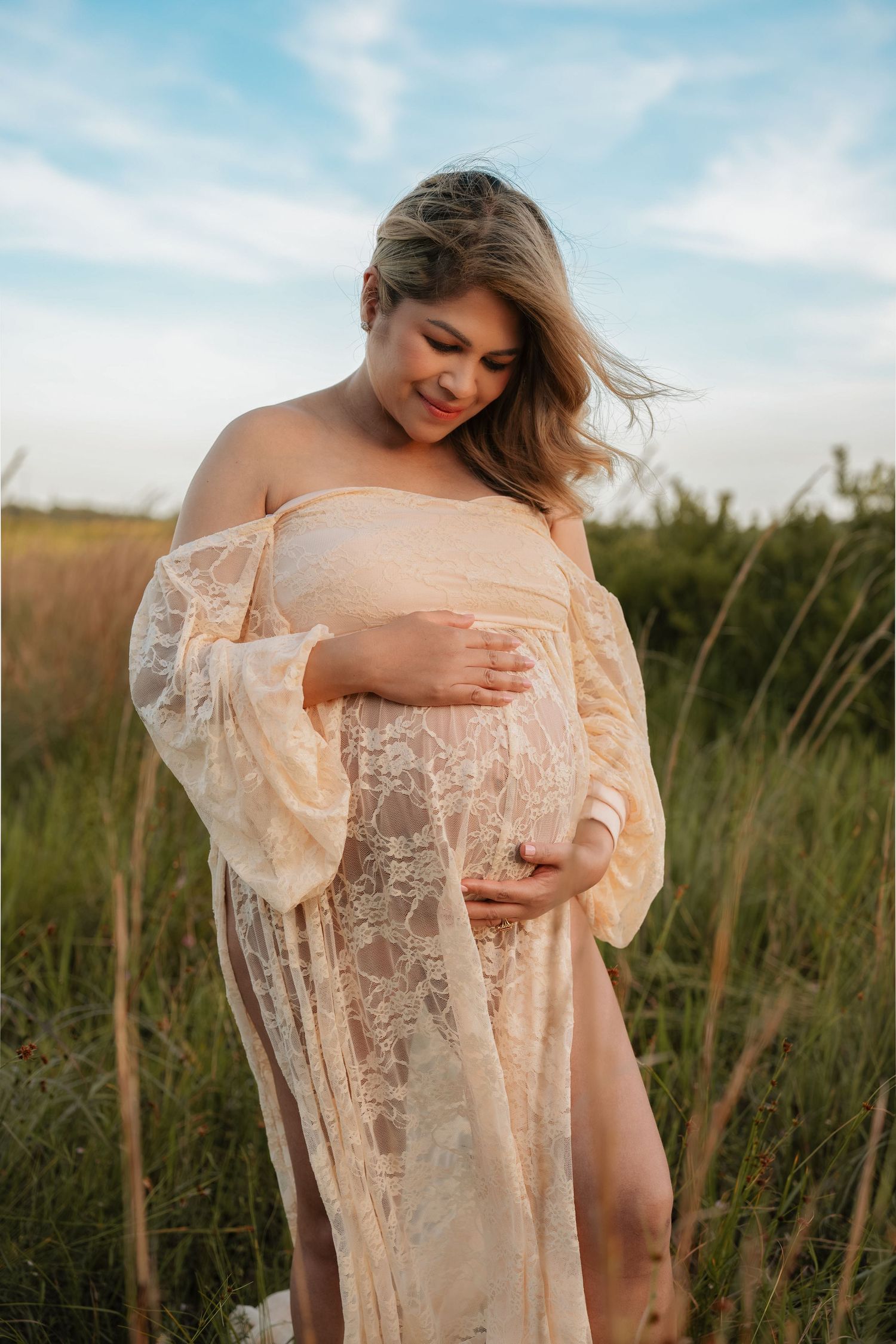 Warm and timeless maternity session photographed among the tall grass at Lake Runnymede Conservation Area in St. Cloud.