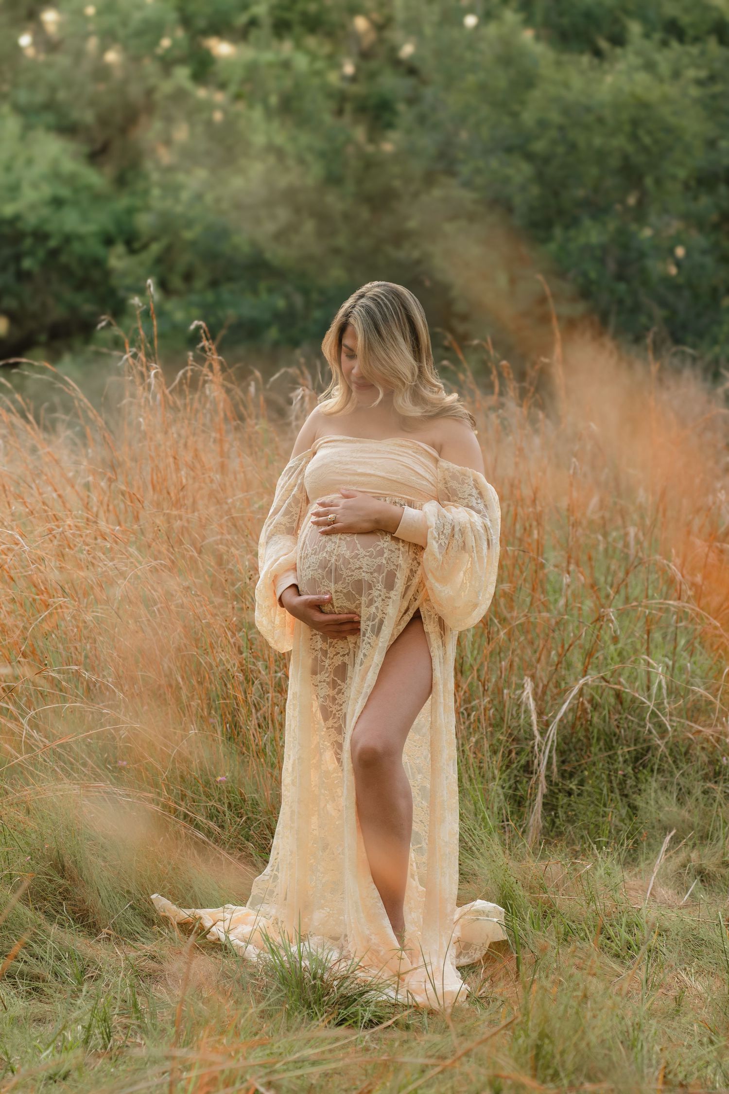 Expecting mother wearing a flowing maternity dress during a rustic outdoor session at Lake Runnymede Conservation Area in St. Cloud, Florida