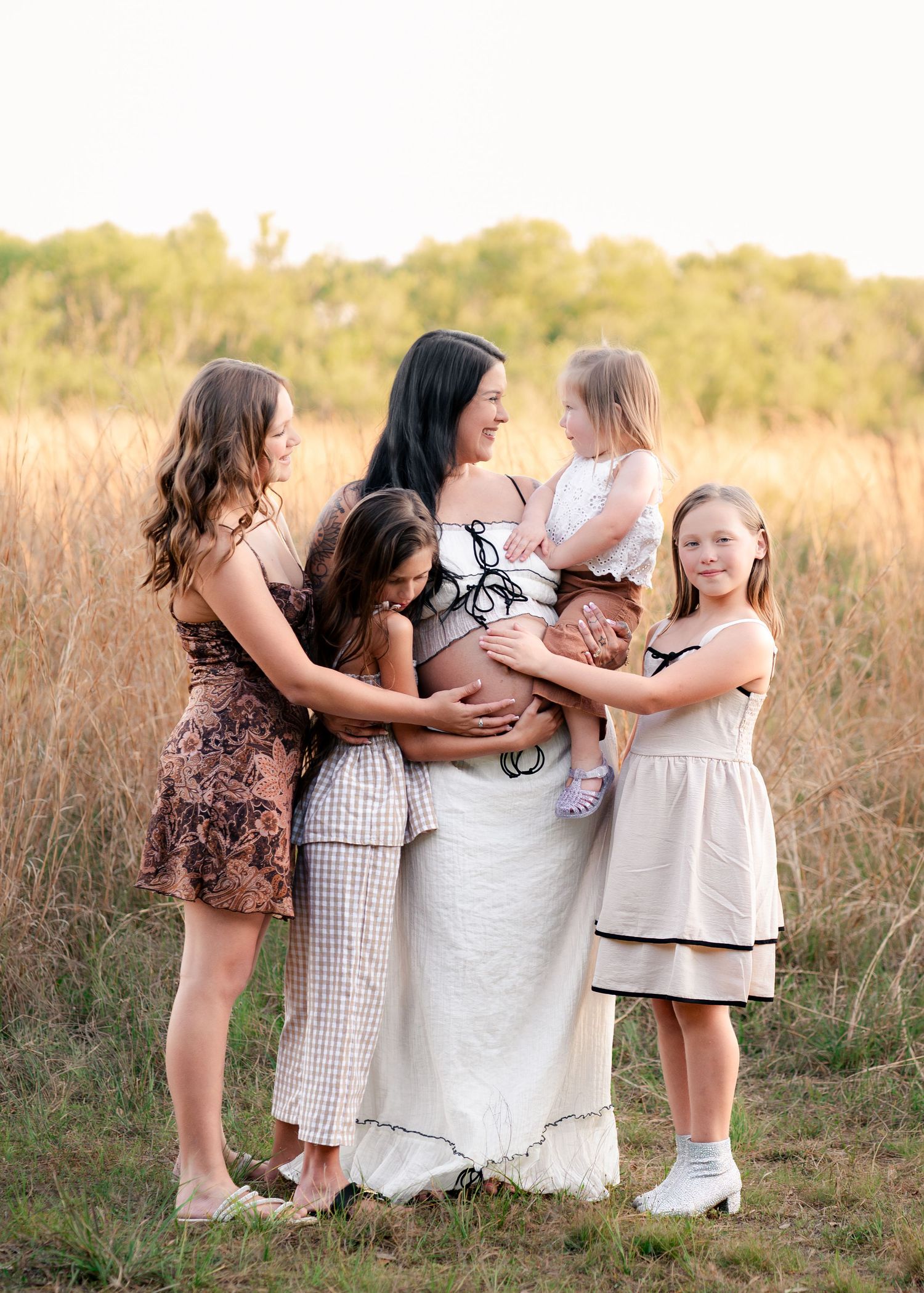 Mother surrounded by her daughters during an outdoor maternity session at Lake Runnymede Conservation Area in St Cloud Florida.
