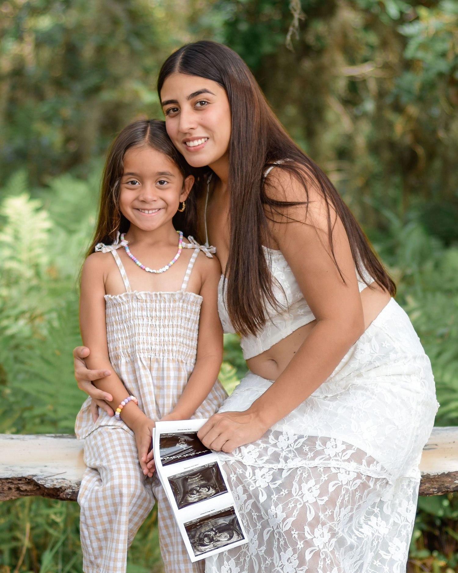 Pregnancy announcement photography featuring mom and daughter embracing outdoors in Orlando Florida