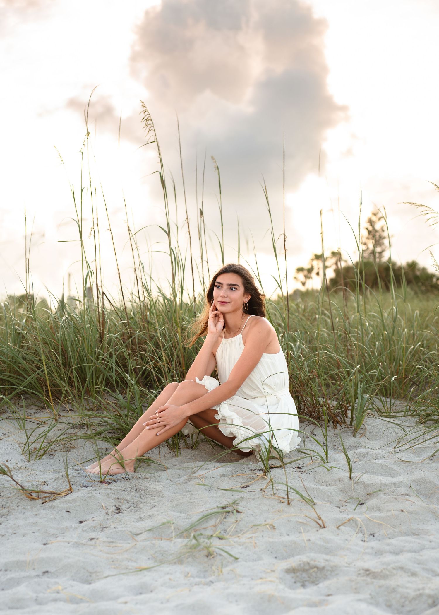 Beautiful senior graduation photography featuring the sandy shoreline, dunes, and golden sunset at Melbourne Beach.