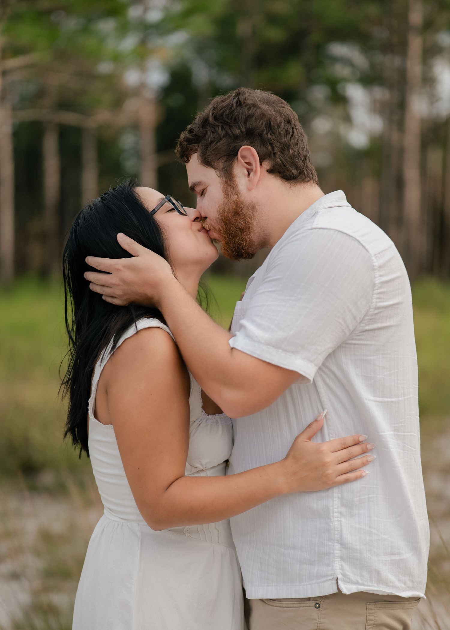 Engaged couple sharing a kiss during golden hour in Florida