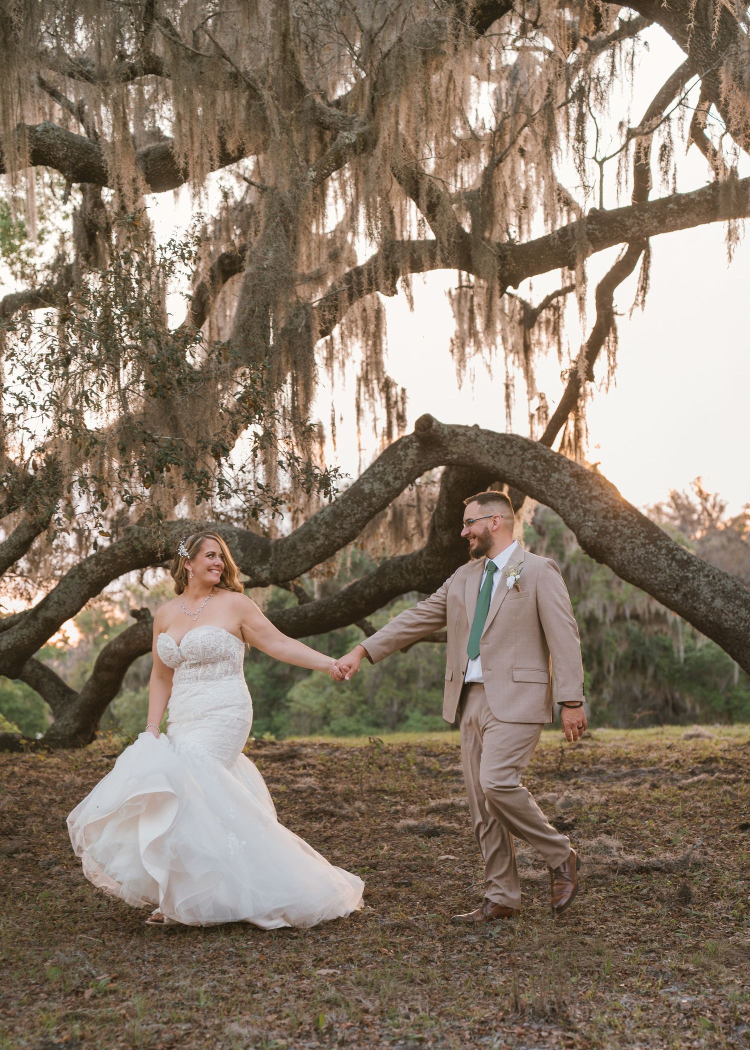 Elegant sunset wedding portraits beneath sprawling oak trees at Moss Estates wedding venue in Central Florida