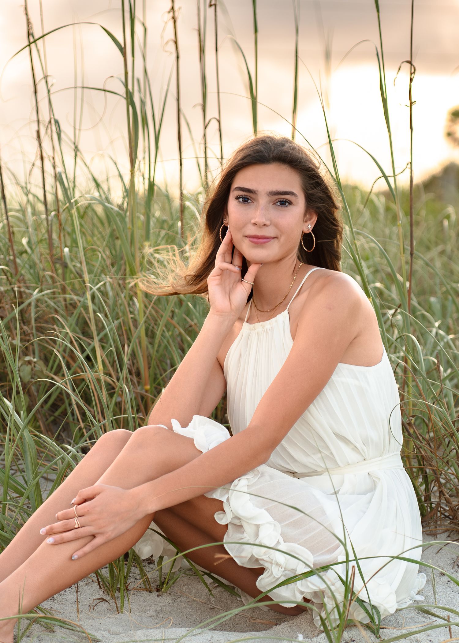 Beautiful senior graduation portrait photography featuring the sandy shoreline, dunes, and golden sunset at Melbourne Beach.
