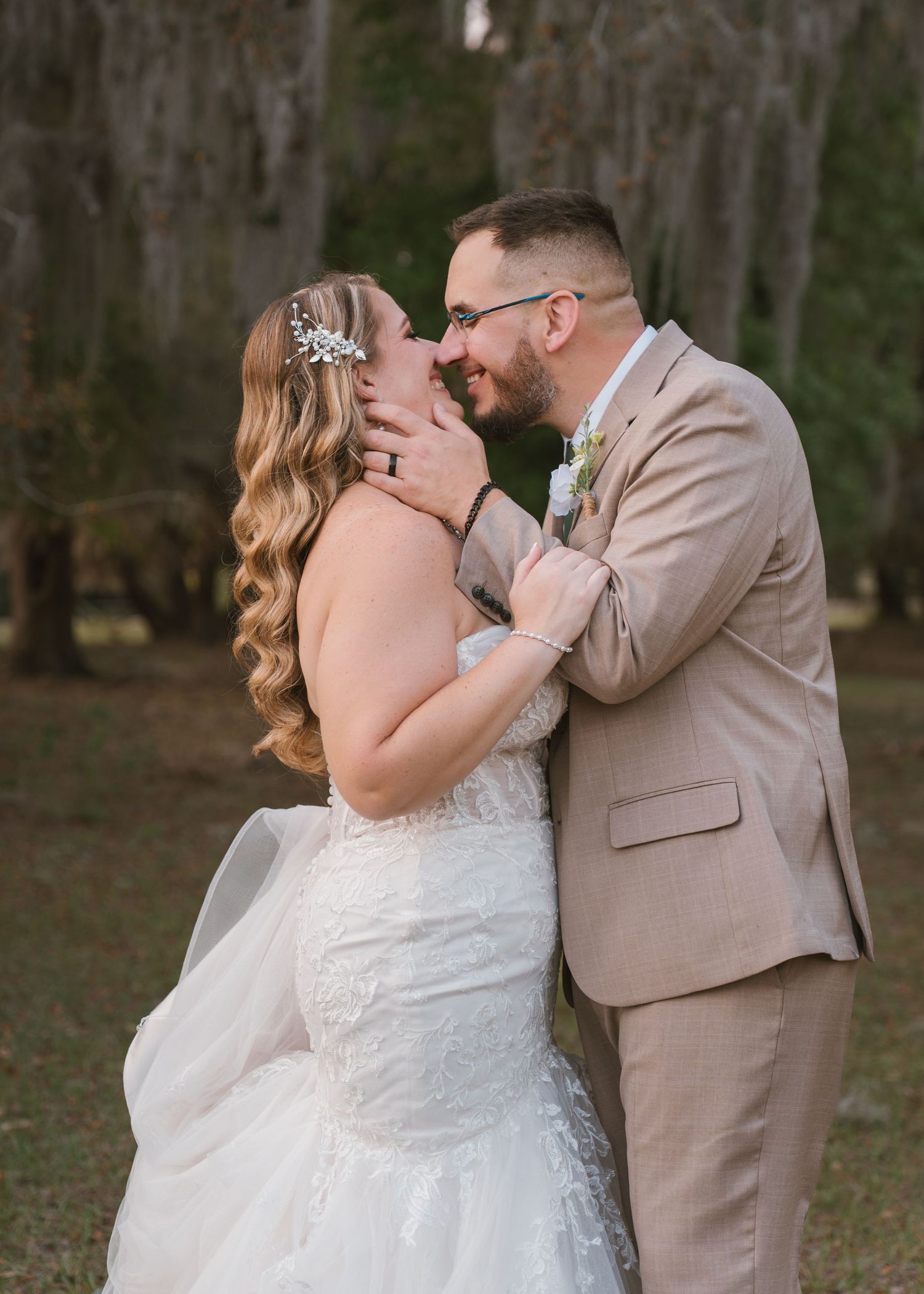 Newly married couple embracing during sunset portraits in the open field at Moss Estates wedding venue.