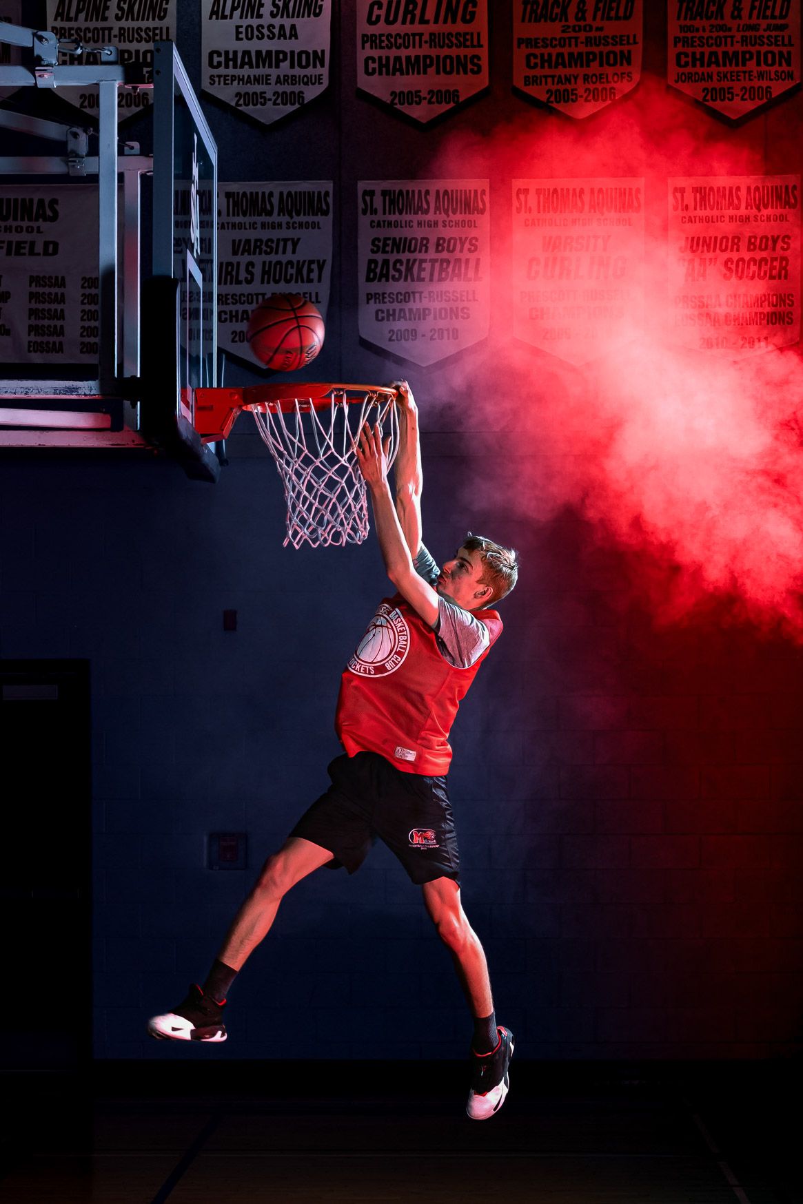 Action portrait of a basketball player doing a layup using dramatic studio lighting and effects by The Show Sports Media