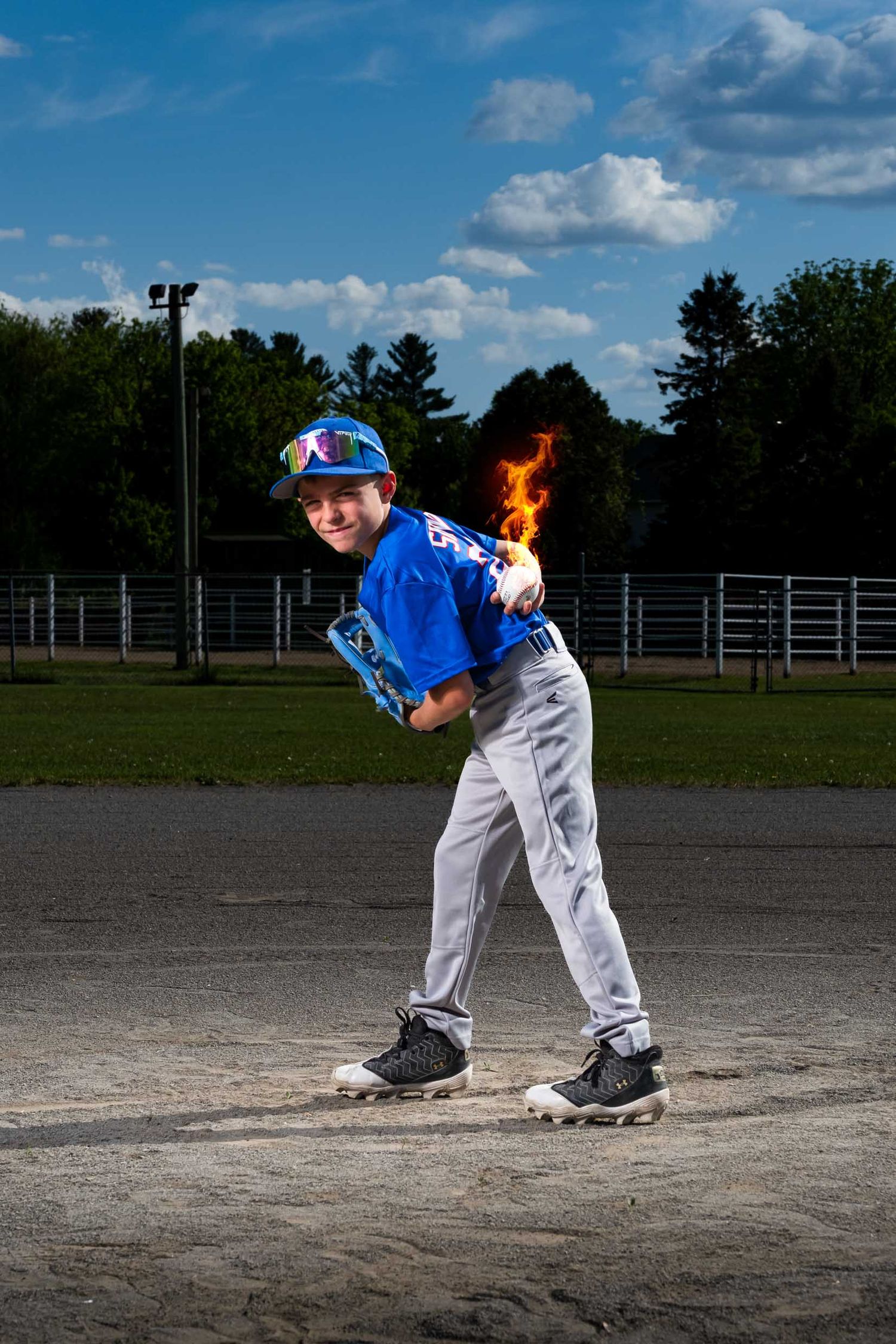 Baseball pitcher with ball on fire behind his back getting ready to pitch