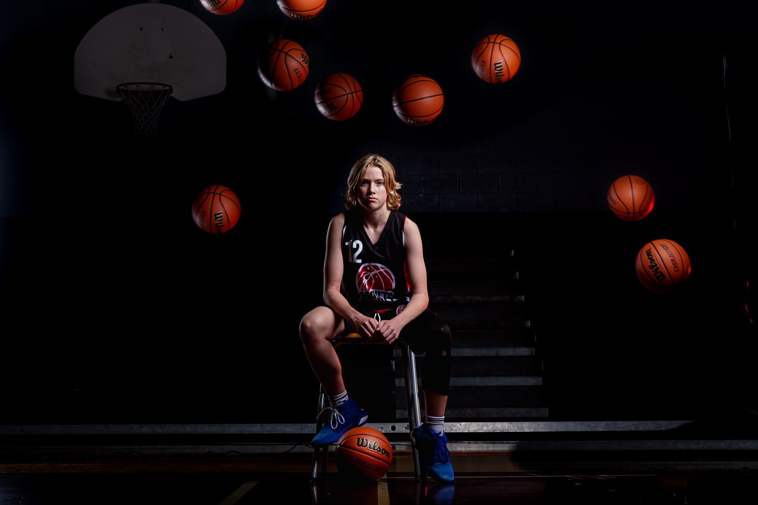 Cinematic basketball portrait of a male basketball player with studio lighting and balls flying above