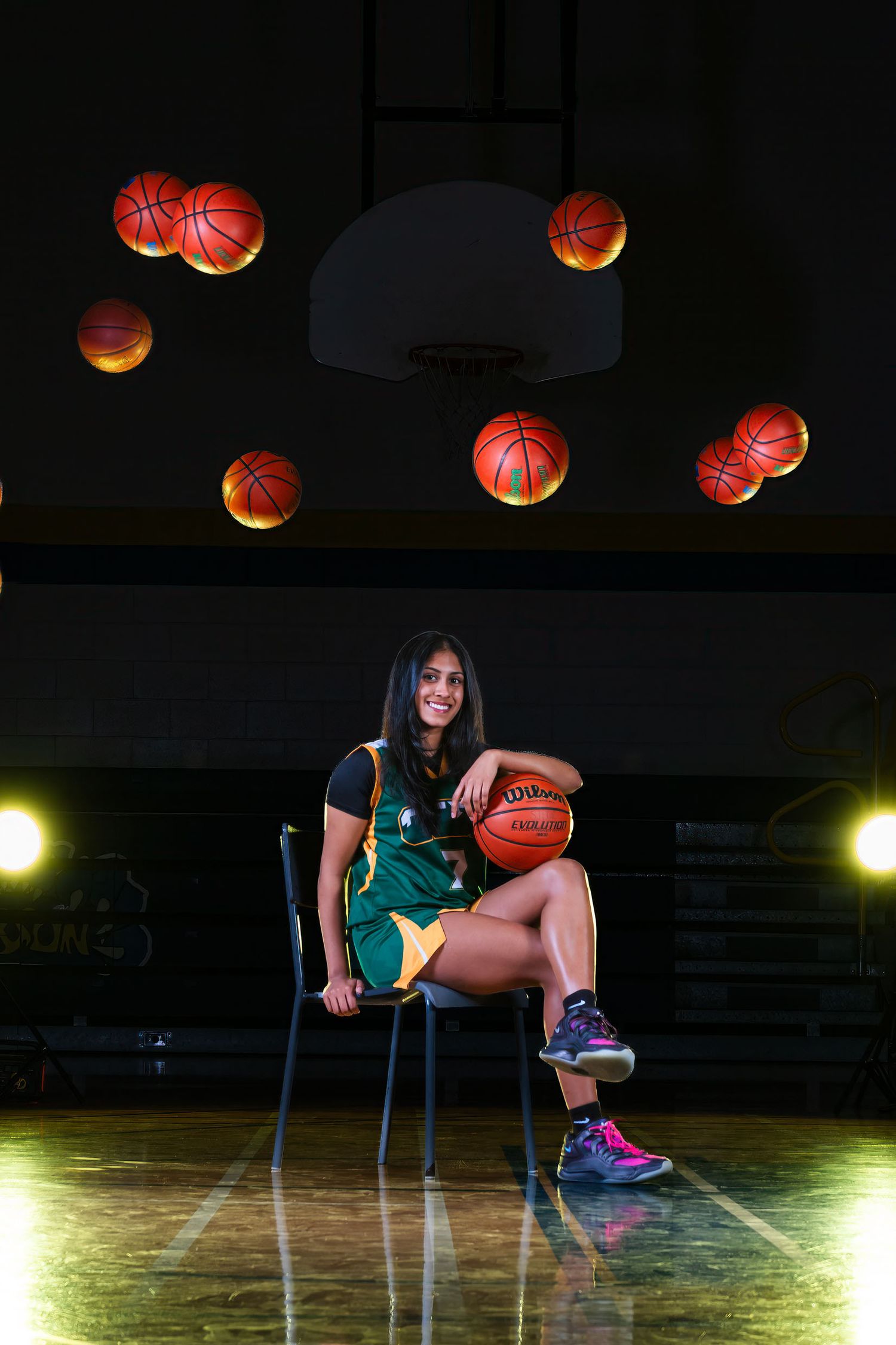 Creative basketball media day action portrait with specialized in-camera effects showing a player seated while basketball fly over her
