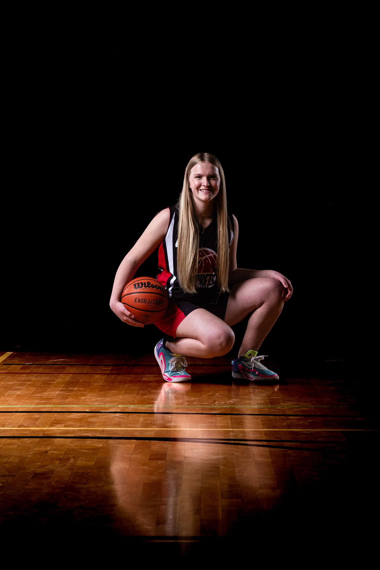 Cinematic basketball portrait of a basketball player crouching on the court