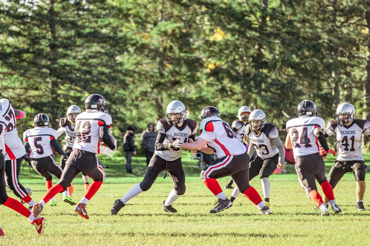 Competitive Ottawa football game action sequence showing offensive and defensive lines clashing on a sunny fall afternoon.