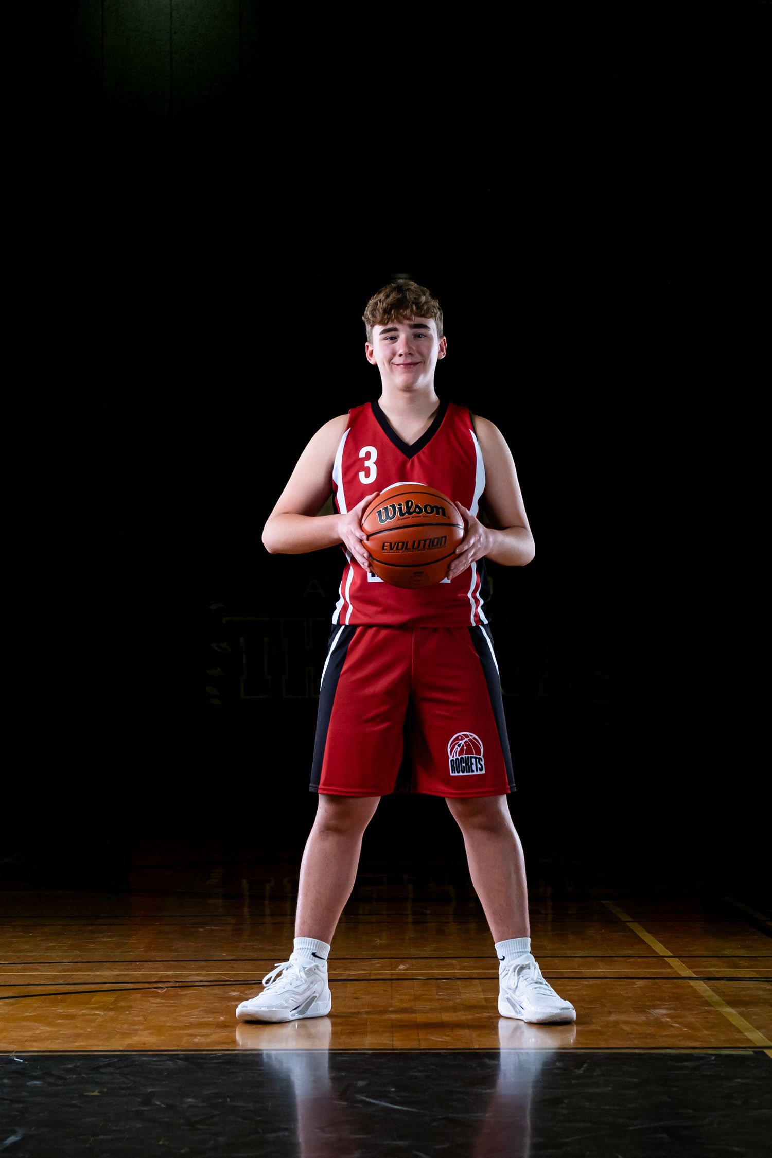 Elite Ottawa sports photography media day feature showing a moody, cinematic portrait of a basketball player under dramatic rim lighting