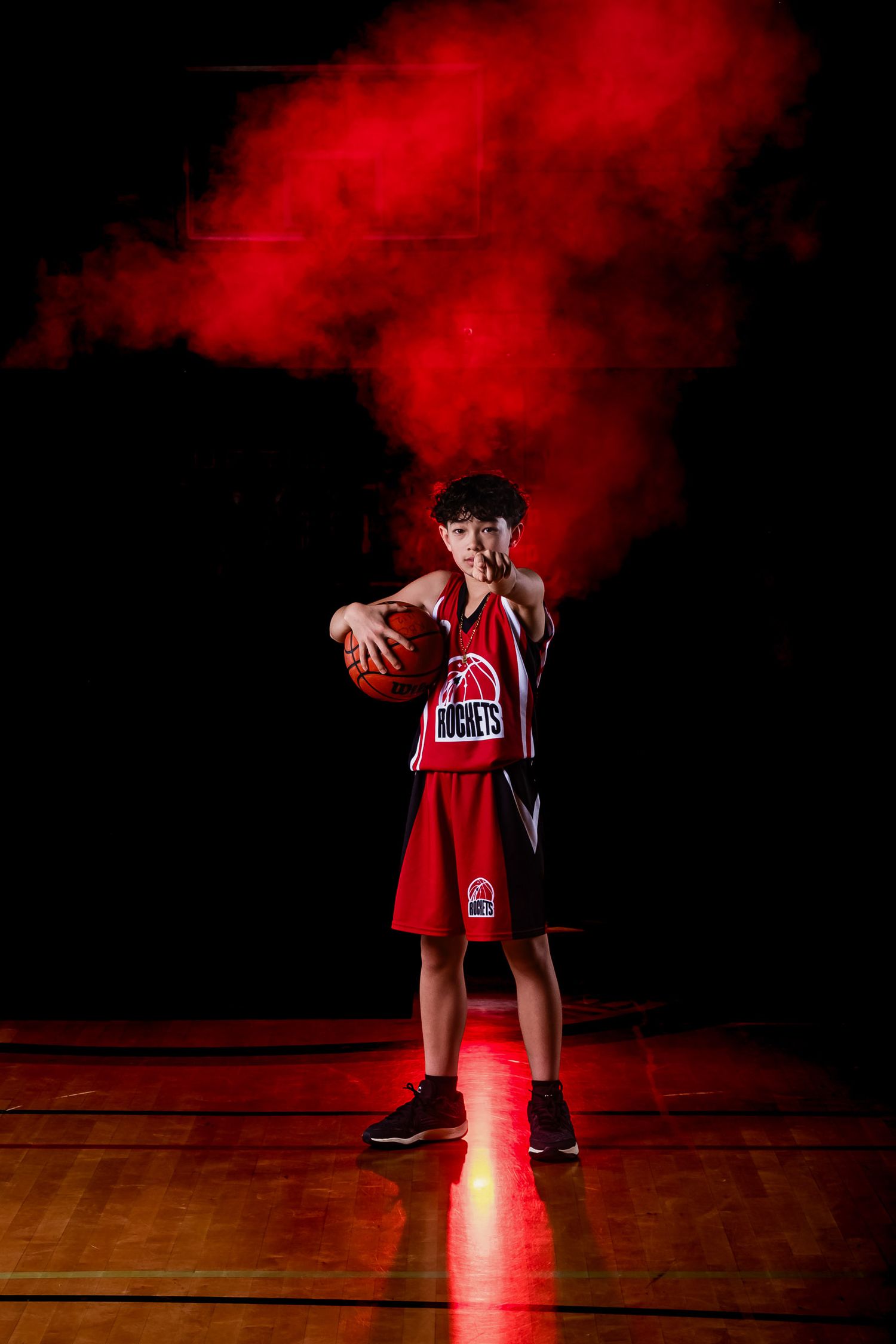 Basketball player in dramatic lighting pointing at the camera with fog effects by The Show Sports Media in Ottawa