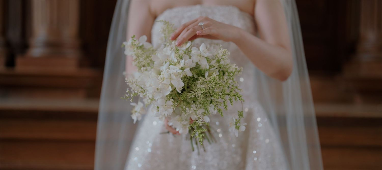 A close-up view of a white wedding dress with delicate lace details and floral embellishments.