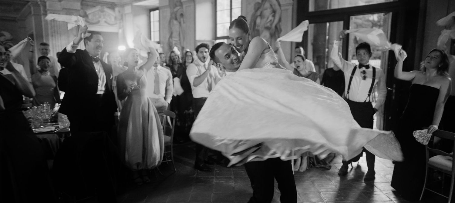 Black and white photos showing a couple dancing at their wedding reception with guests watching and celebrating.