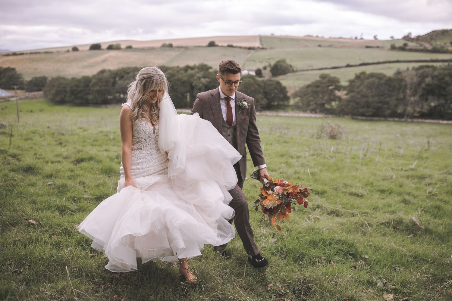 Bride and groom strolling through scenic Scottish countryside during a luxury countryside wedding