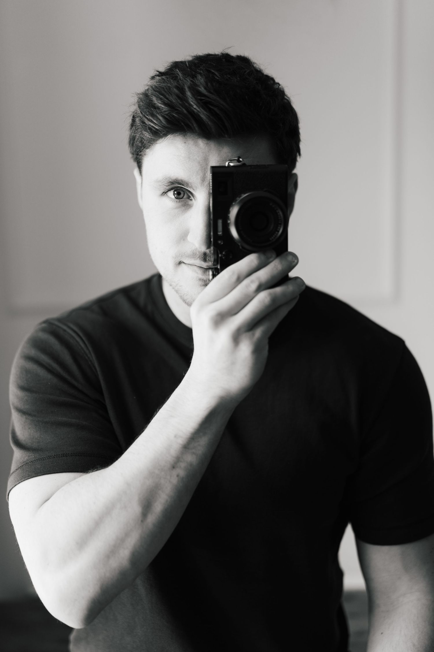 A black and white photo series showing a person covering their face with their hand in different poses.
