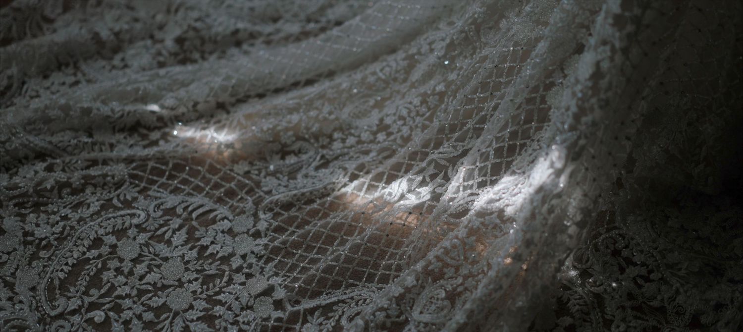 Window light shimmering across a bride's dress during the morning preparations before the wedding ceremony.