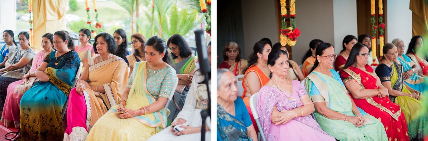 Wedding guests in vibrant saris watching traditional ceremony proceedings in a decorated venue.
