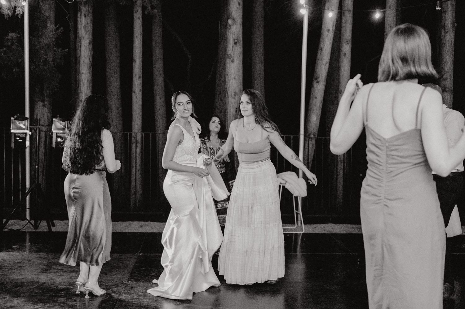 People dancing during a celebration in elegant dresses captured in black and white.