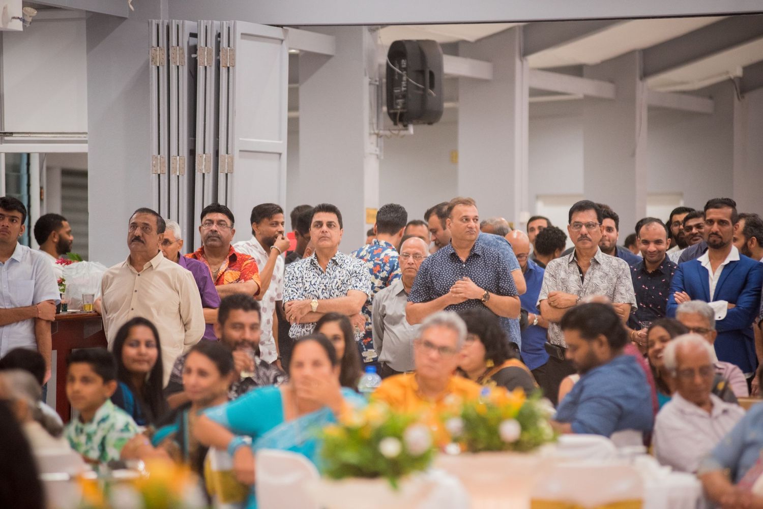 Large group of guests seated at reception tables enjoying the celebration.