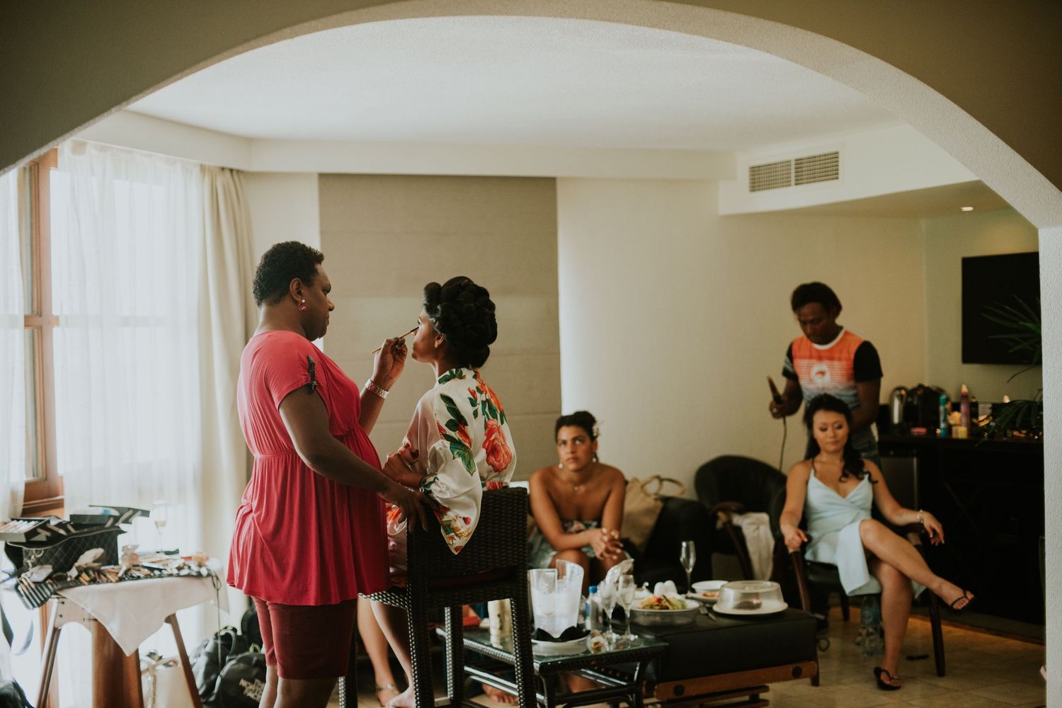 Wedding party getting ready in a hotel room with casual atmosphere.