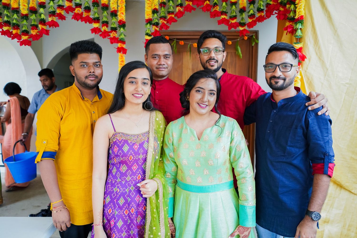 Group photo of celebration attendees wearing colorful traditional Indian attire.