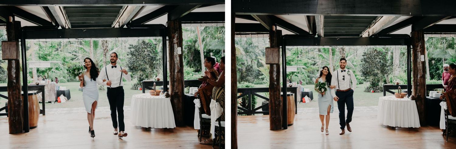 Indoor wedding venue with exposed beams and white decorations surrounded by lush tropical landscaping.