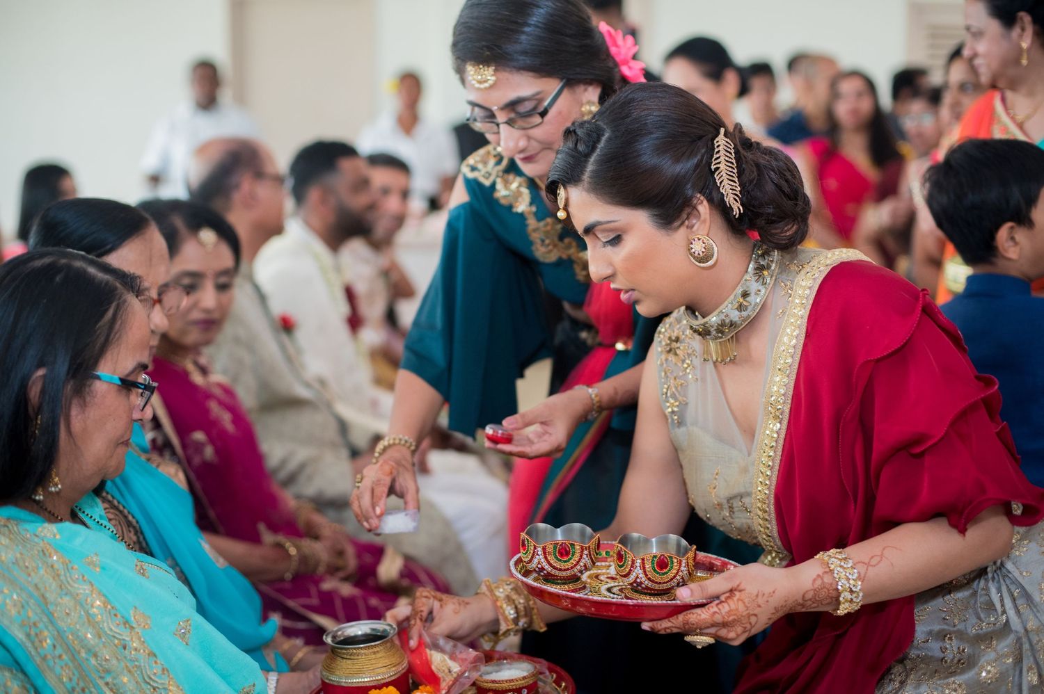 Guests at a traditional Indian celebration sharing food and offerings during a cultural ceremony.