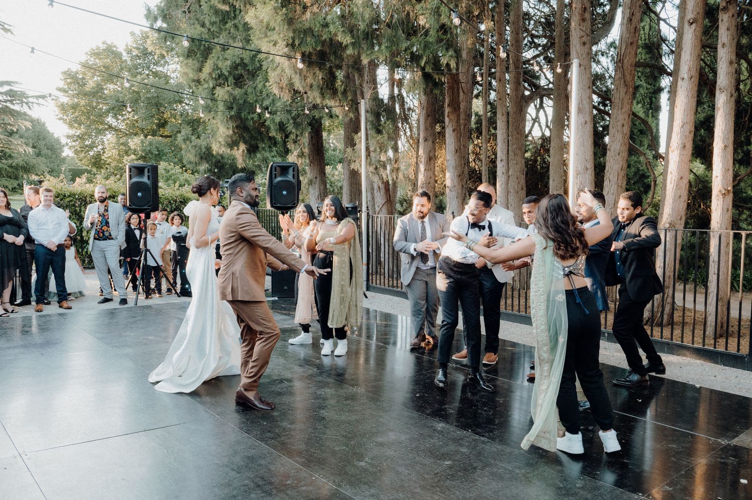 Couples dancing on an outdoor dance floor during a wedding celebration.