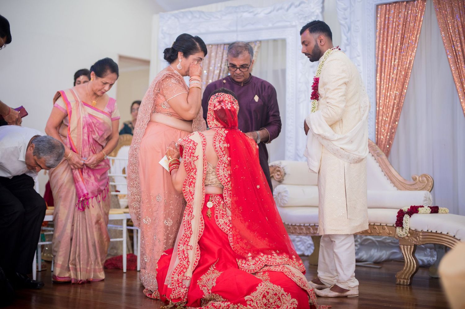 Traditional wedding ritual being performed with guests watching in an elegantly decorated venue.
