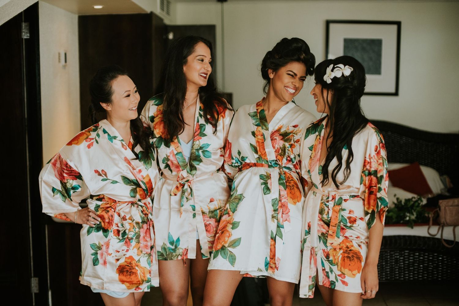 Wedding party in matching floral robes standing together during preparations.