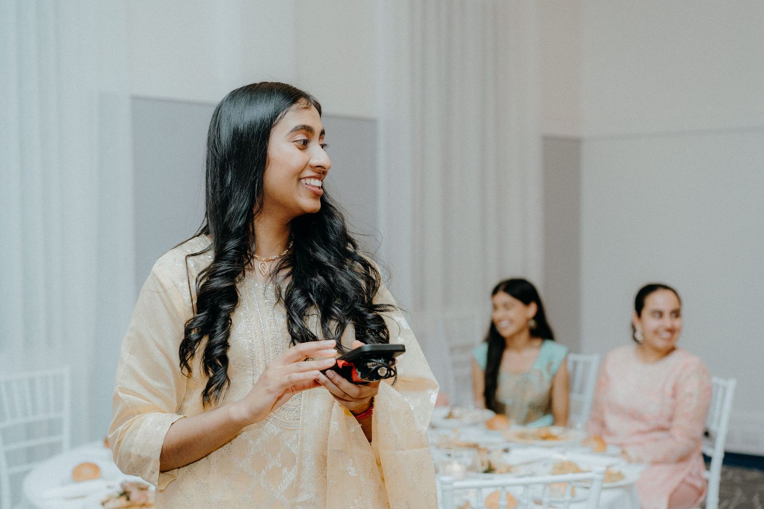 Guest enjoying refreshments at an elegant wedding reception with white chairs in background.