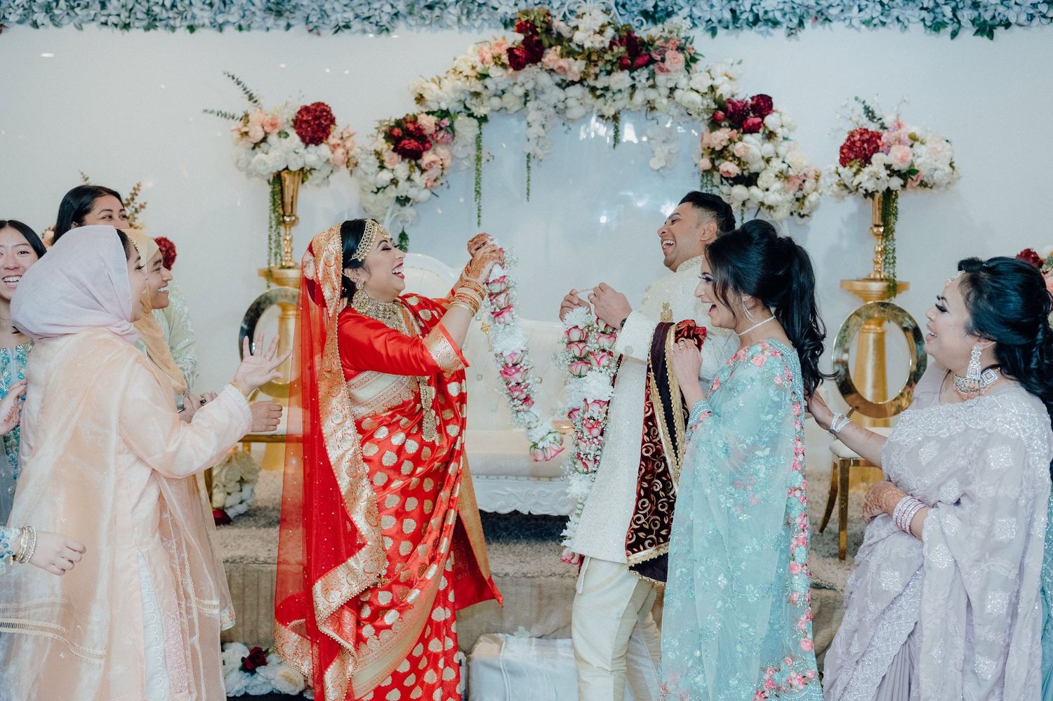 Celebratory dance moment at wedding reception with guests in traditional formal attire.