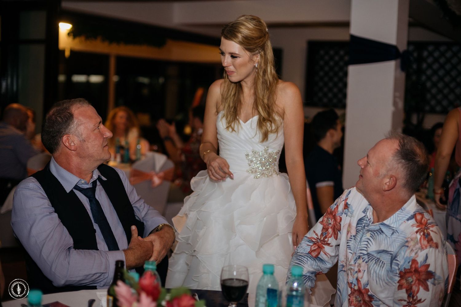 A reception scene showing guests engaged in conversation at a formally set dinner table.