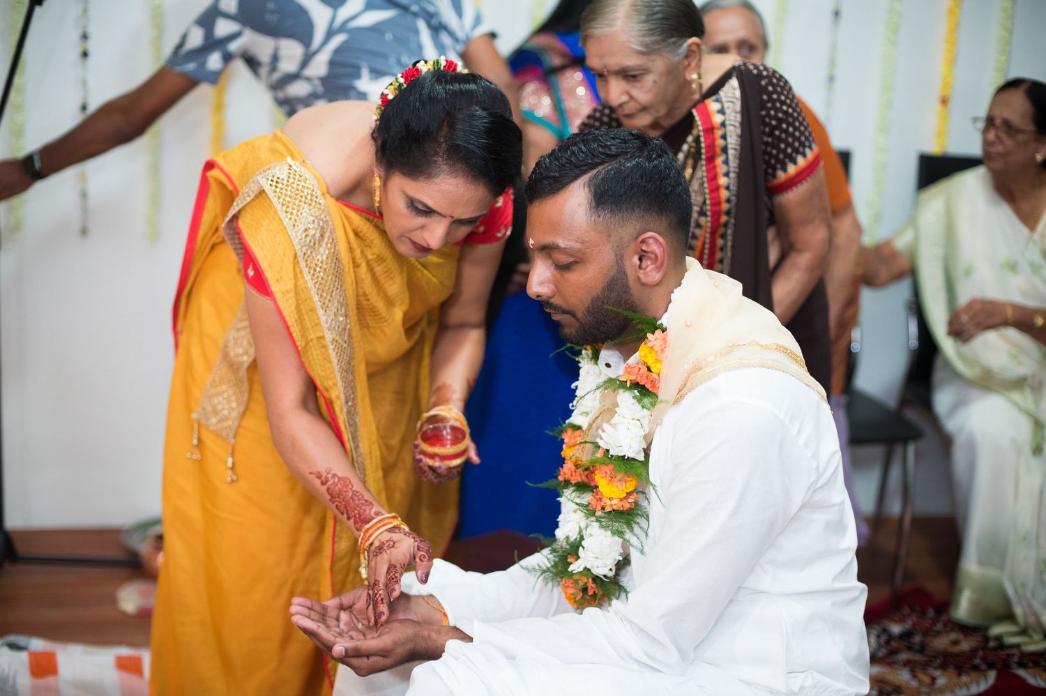 A traditional Indian ceremony where ritual blessings are being performed with guests looking on.