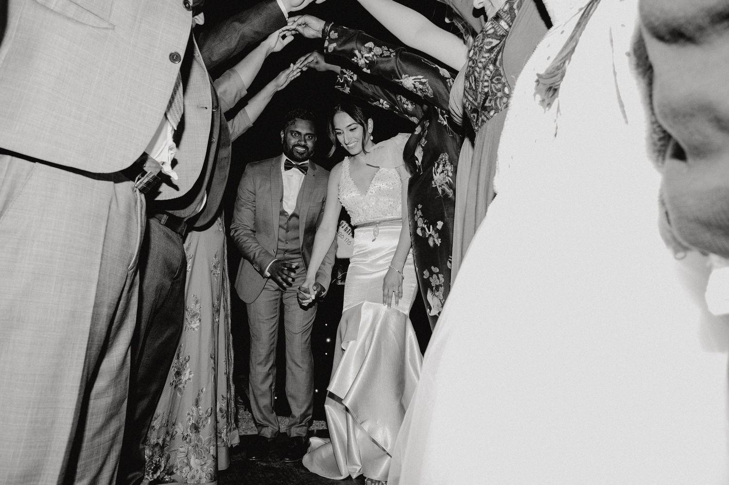 Wedding party captured in intimate black and white moment during celebration.