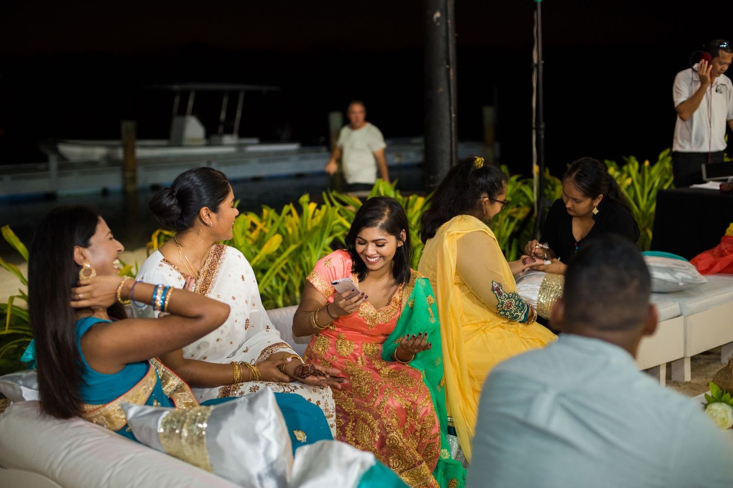 Evening celebration with guests dining and socializing at outdoor tables.