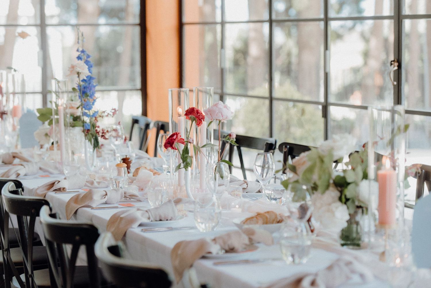 Elegant wedding table settings with crystal glasses and delicate floral arrangements.