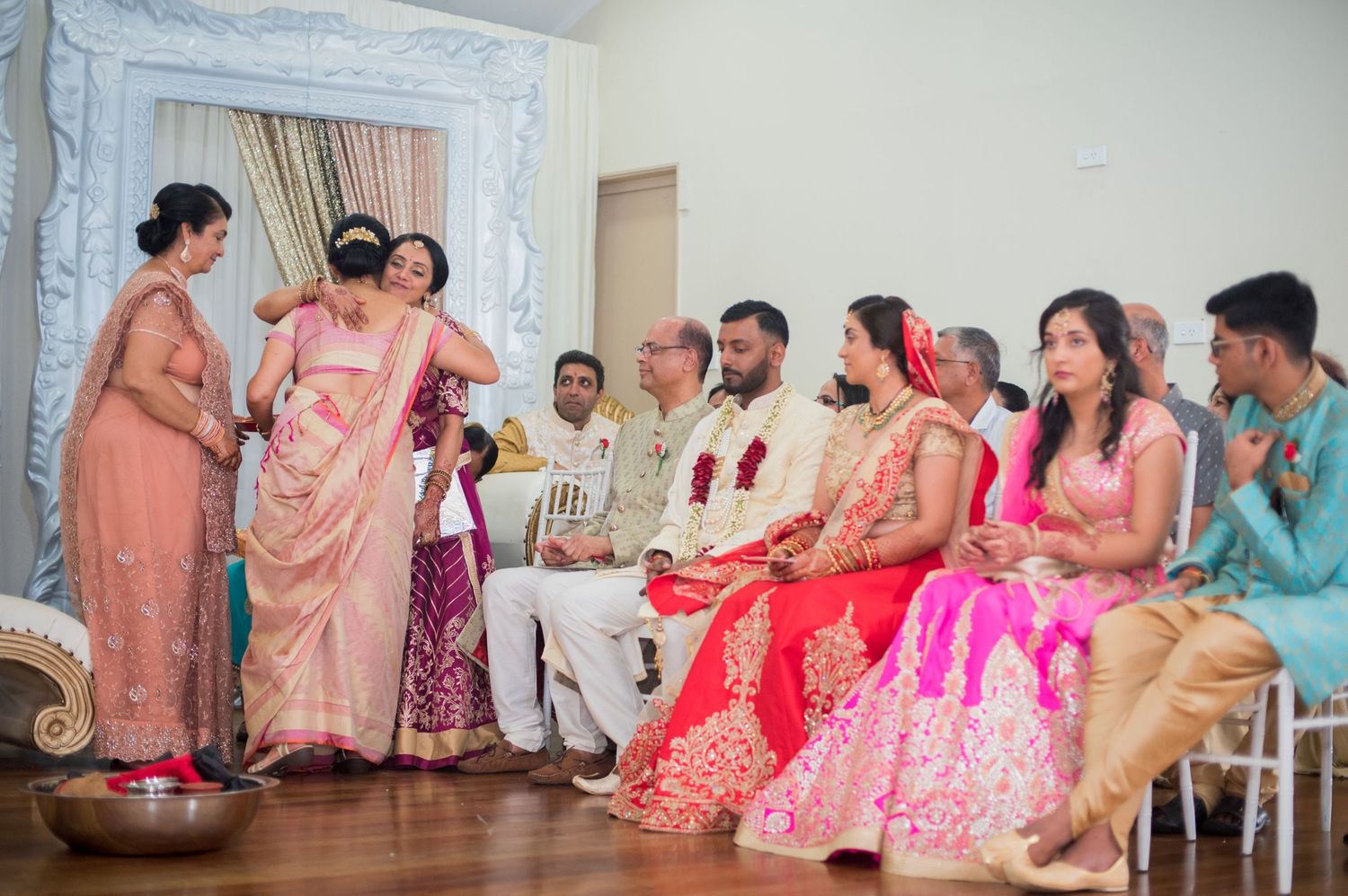 Wedding guests and family members gathered during a traditional ceremony with colorful attire.