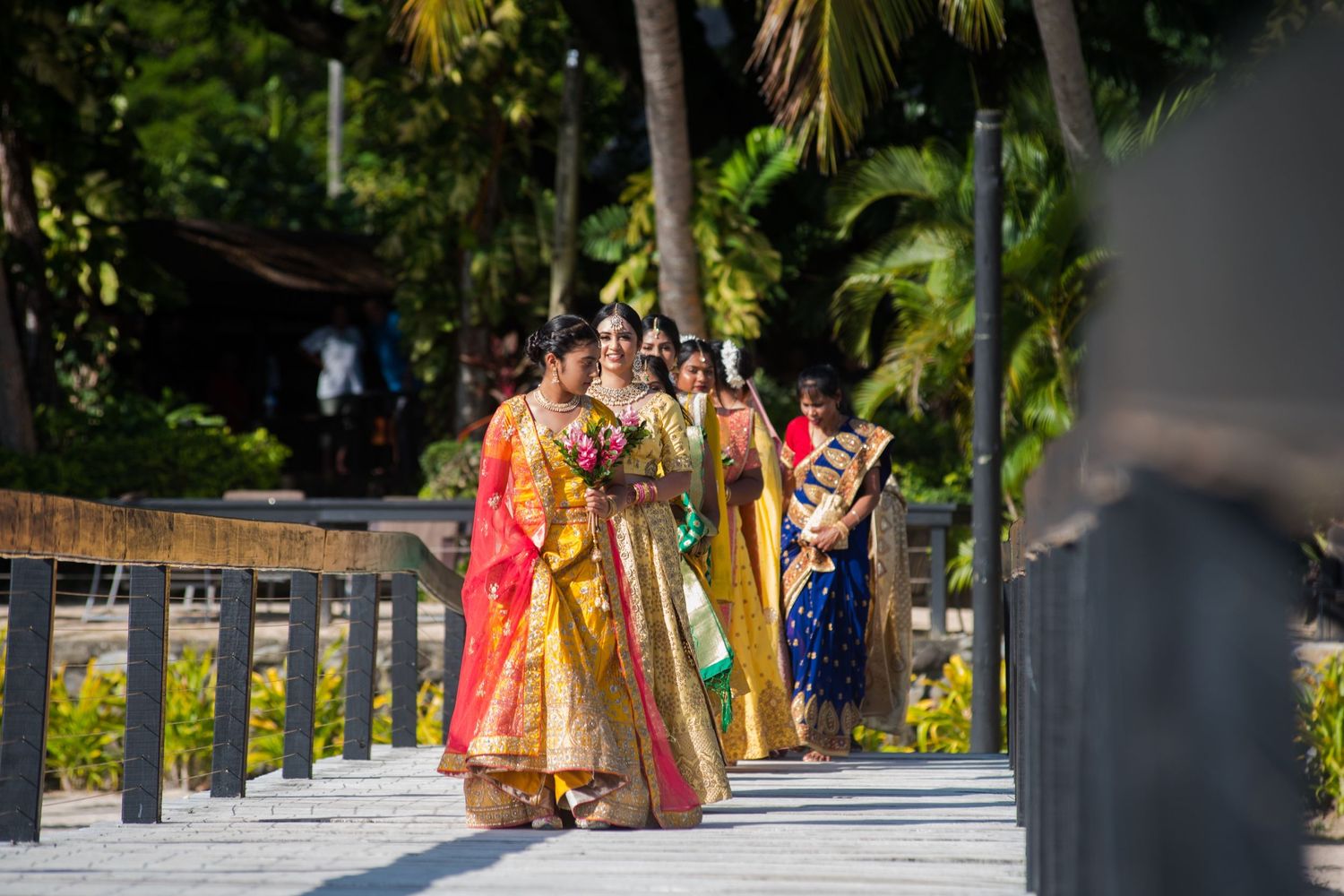 Wedding procession with attendees wearing colorful traditional Indian garments.